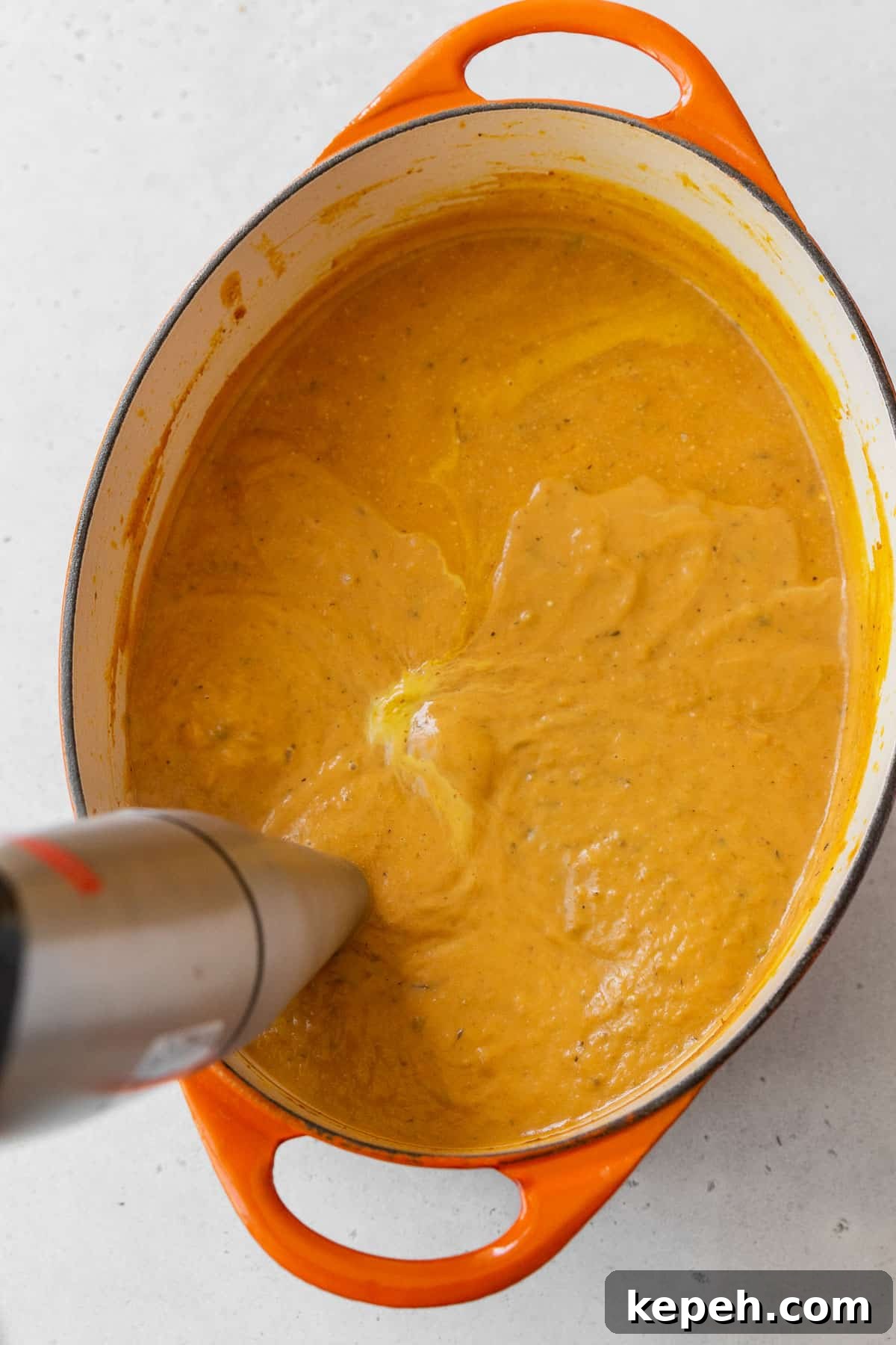 Creamy Plant-Based Pumpkin Soup Recipe for Fall Comfort 9 Using an immersion blender to purée the gluten-free and vegan pumpkin bisque soup.