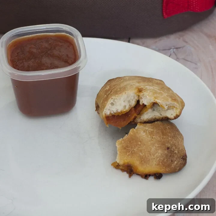 You'll be parent of the year when you send your kids back to school with mini pepperoni calzones. They're easy to make in bulk and freeze. #SundaySupper #TheRedheadBaker