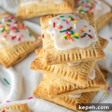 4 stacked strawberry pop tarts on dish towel with more in background