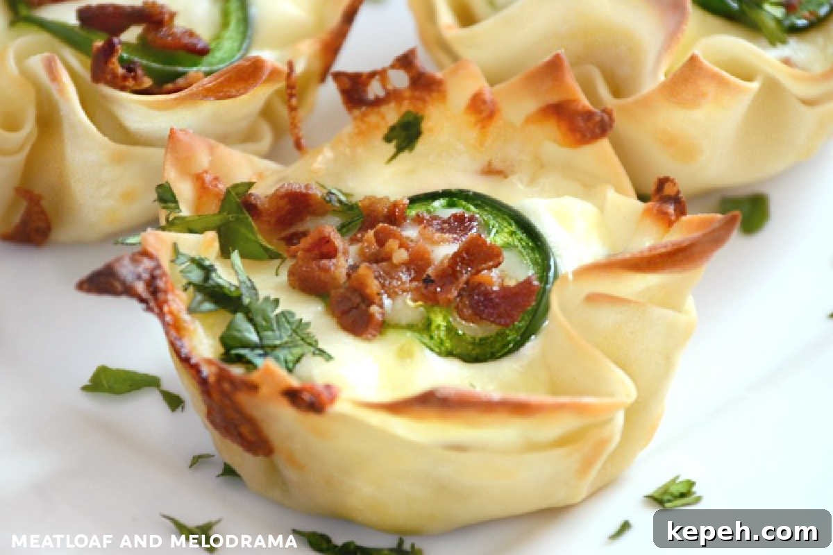 Bacon Jalapeño Popper Wonton Cups — Crispy Bite-Sized Appetizers 2 jalapeño popper wonton cups on a plate with cilantro and bacon bits