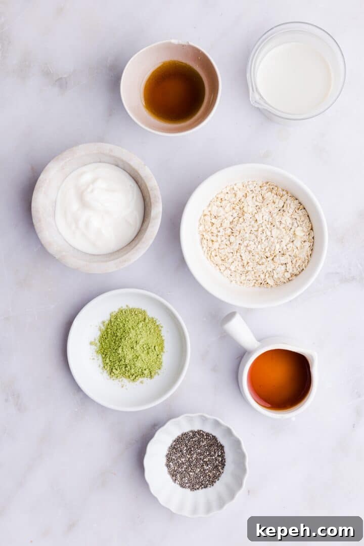 Ingredients for matcha overnight oats displayed in small bowls on a white countertop