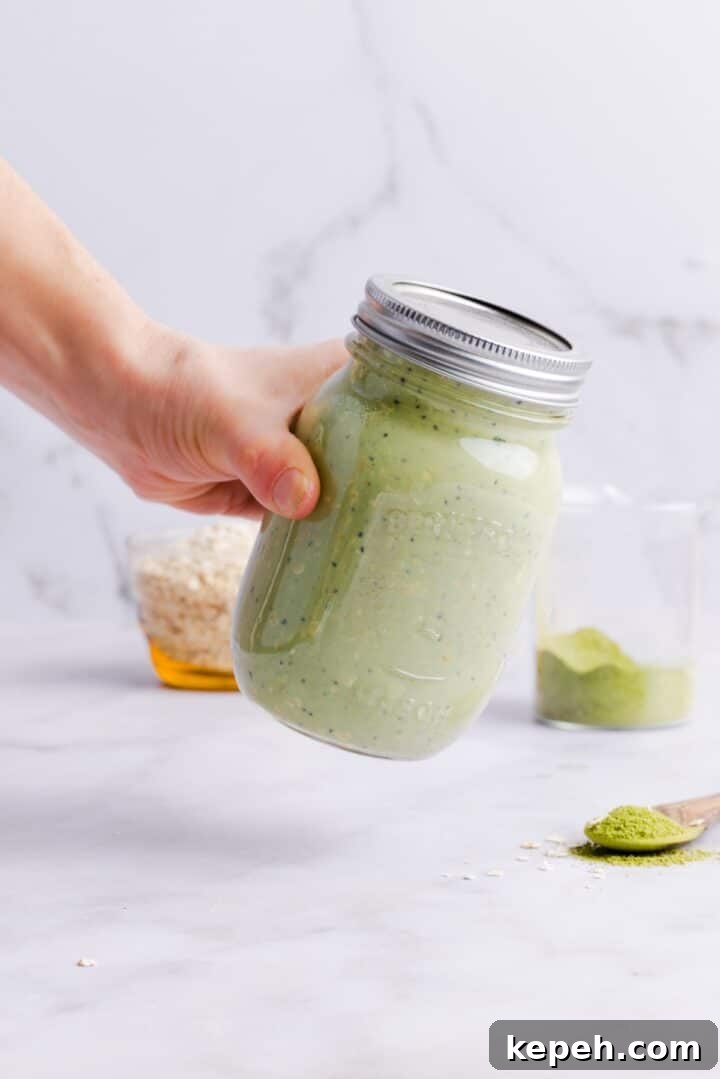 Woman's hands holding a closed glass jar with matcha overnight oats
