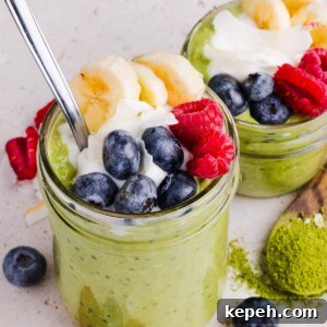 Two jars of matcha overnight oats topped with fruit and yogurt