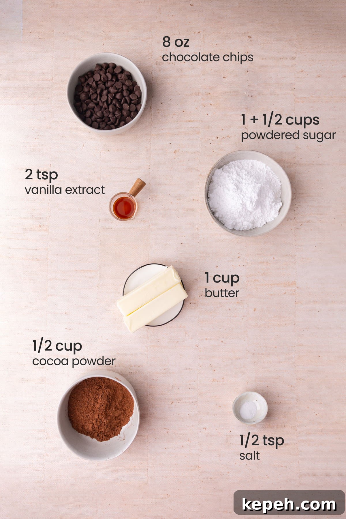 Overhead view of the ingredients needed for chocolate fudge frosting - chocolate chips, vanilla extract, powdered sugar, butter, cocoa powder, and salt.