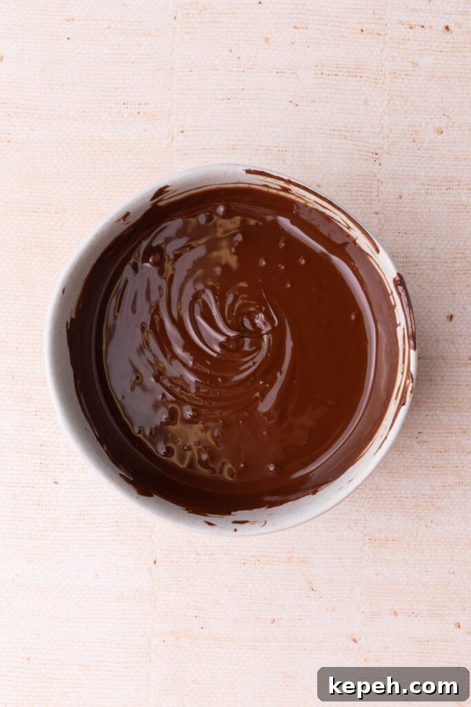 Chocolate chips melted down to liquid in a bowl.