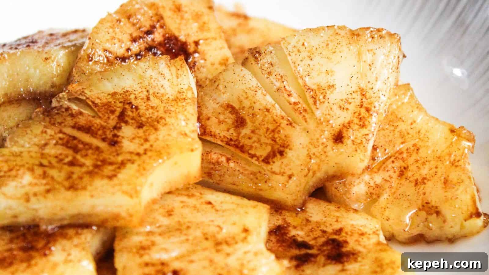 Sliced pinieapples sprinkled with cinnamon on a plate.