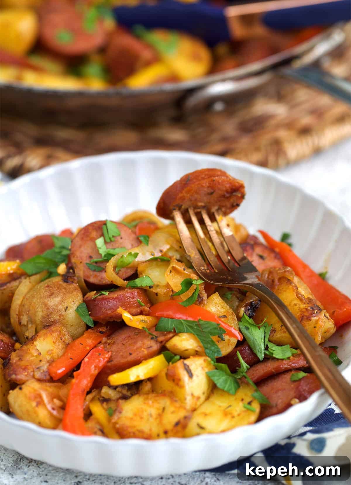 Kielbasa and Potatoes in a white bowl with a fork