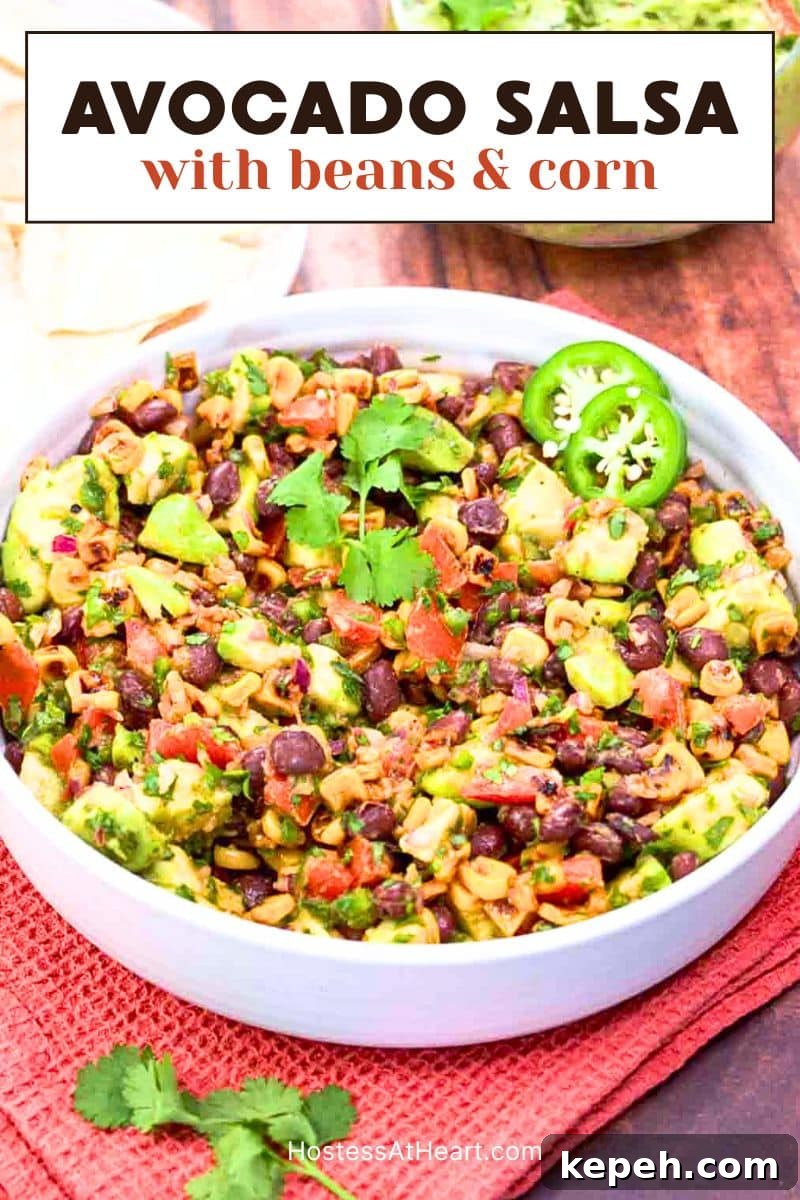 Fresh Avocado Salsa with Corn & Black Beans — Zesty Summer Dip 12 A titled image for Pinterest of Fresh avocado salsa with corn and black beans in a white bowl garnished with cilantro and sliced jalapenos. Hostess At Heart