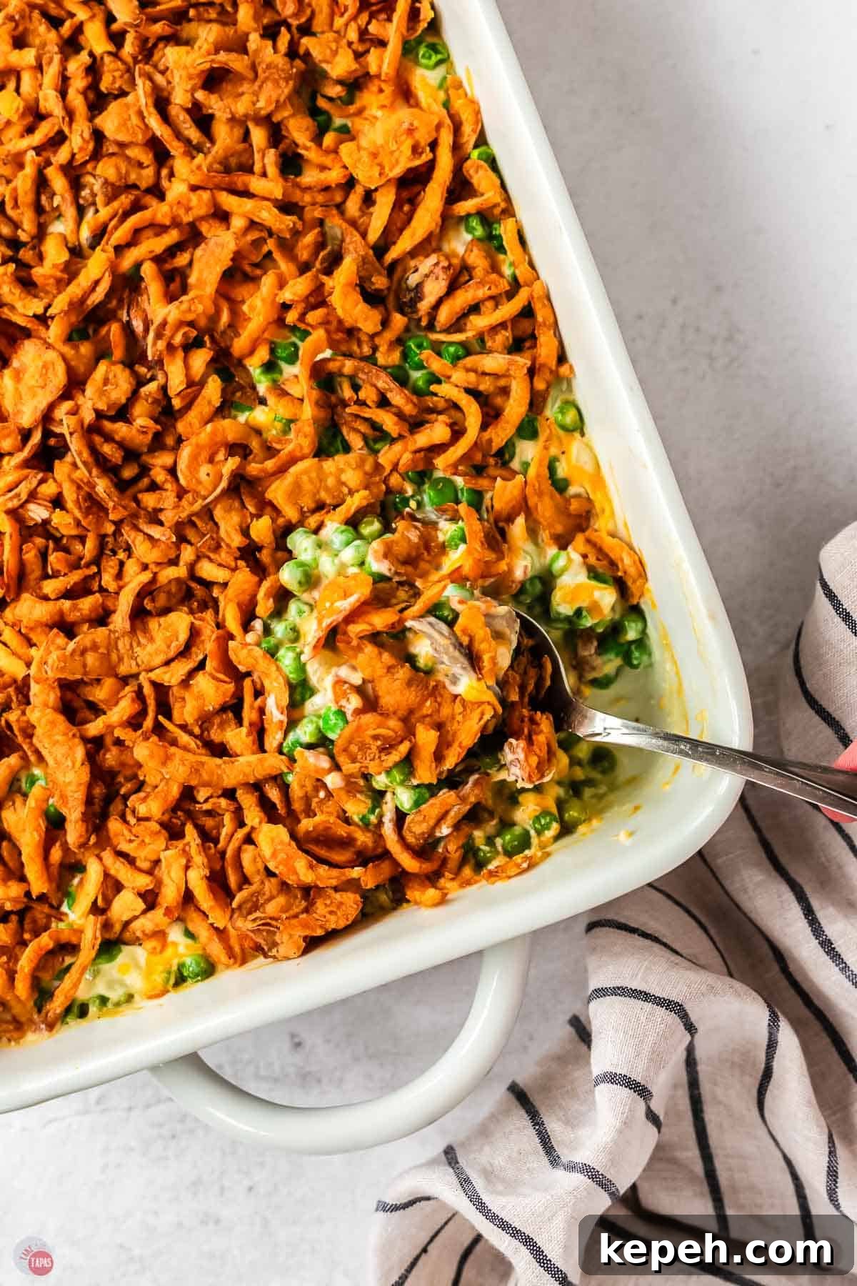 Classic Green Pea Casserole Recipe for Family Dinners 2 overhead picture of spoon scooping casserole out of a white dish