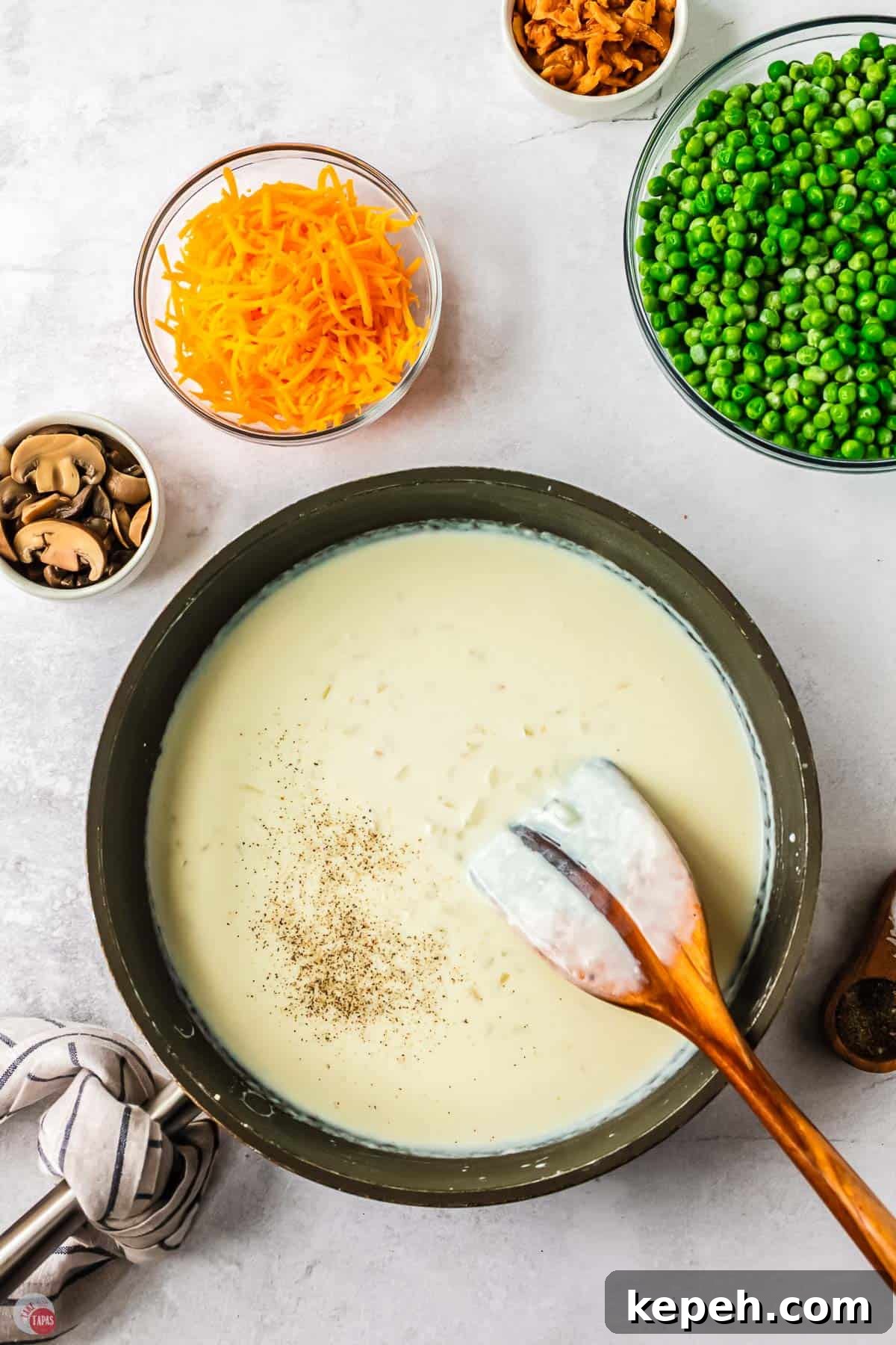 Classic Green Pea Casserole Recipe for Family Dinners 5 skillet with roux and a wood spoon with a line in the roux scraped off