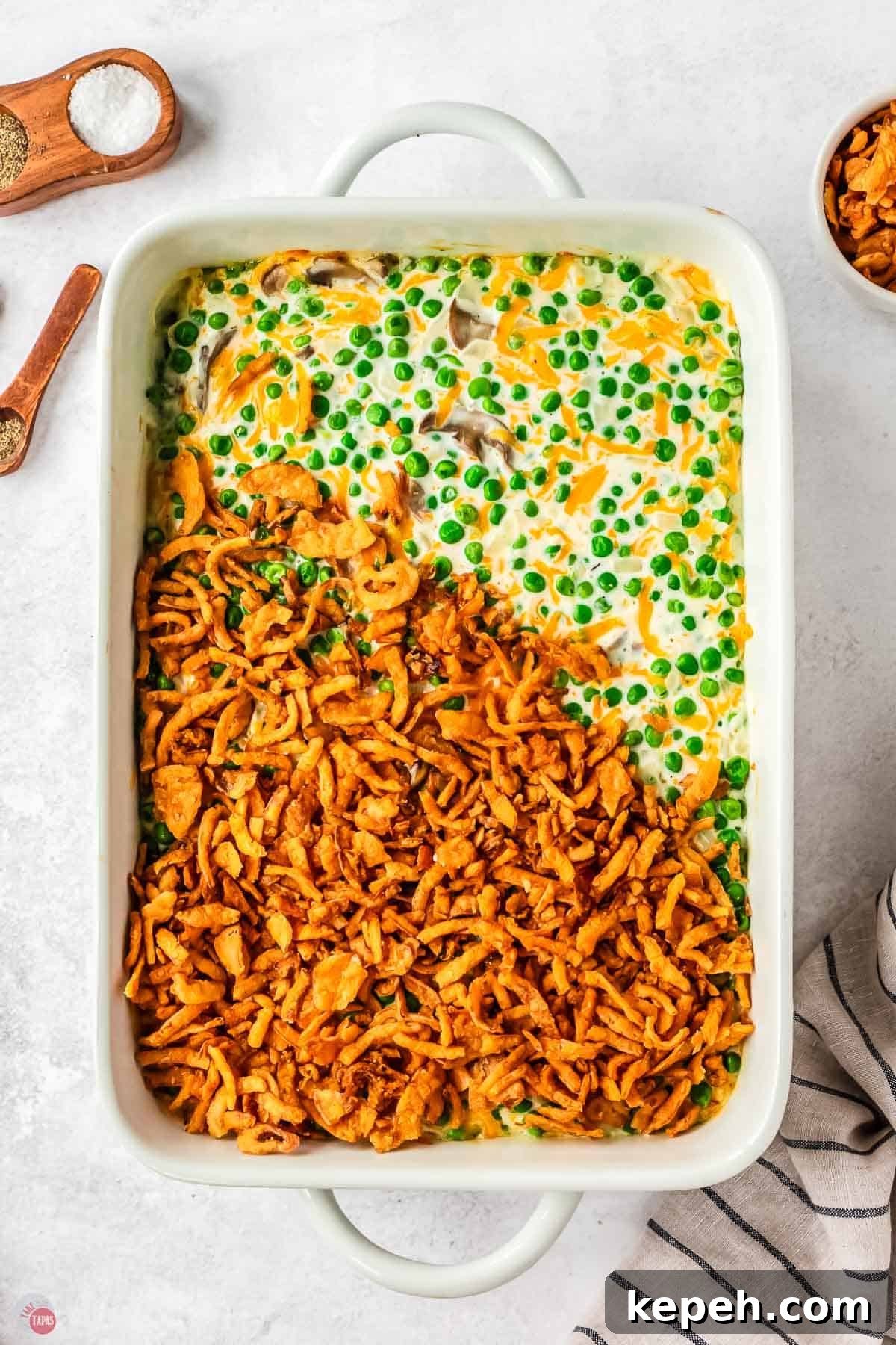 Classic Green Pea Casserole Recipe for Family Dinners 7 pea casserole in a white dish partially covered with fried onions