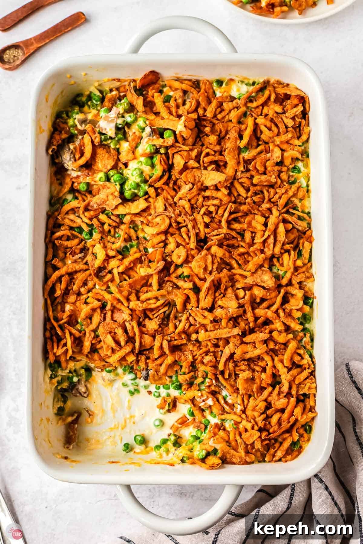 Classic Green Pea Casserole Recipe for Family Dinners 10 white casserole dish with a scoop missing
