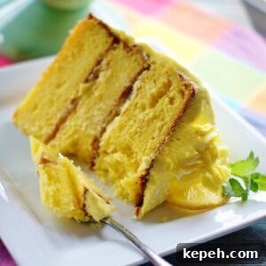 A large slice of lemon cake on a white plate.