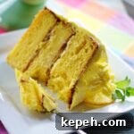 A large slice of lemon cake on a white plate.