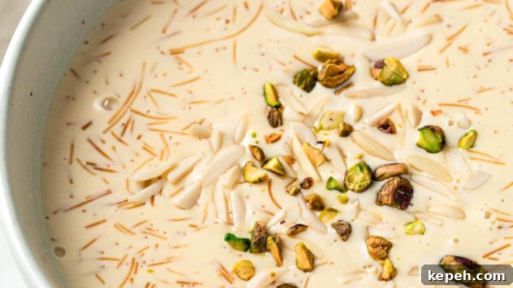 A large bowl with sheer khurma served with spoons and nuts in small bowls