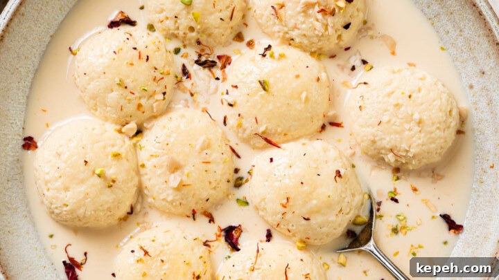 A bowl of Ras Malai garnished with saffron, crushed almonds and pistachios.