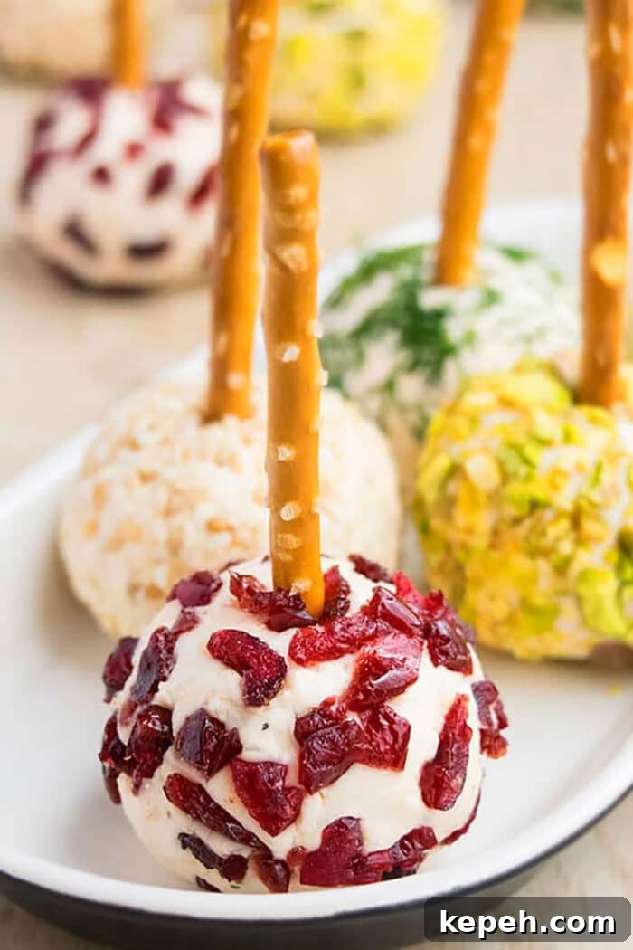 Mini Cheese Bites with Dried Cranberries in White Plate on Wood Surface.