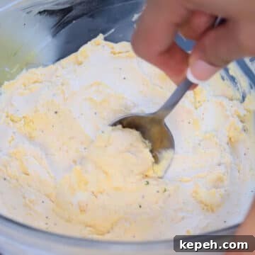 Cheese mixture being scooped with a spoon. 