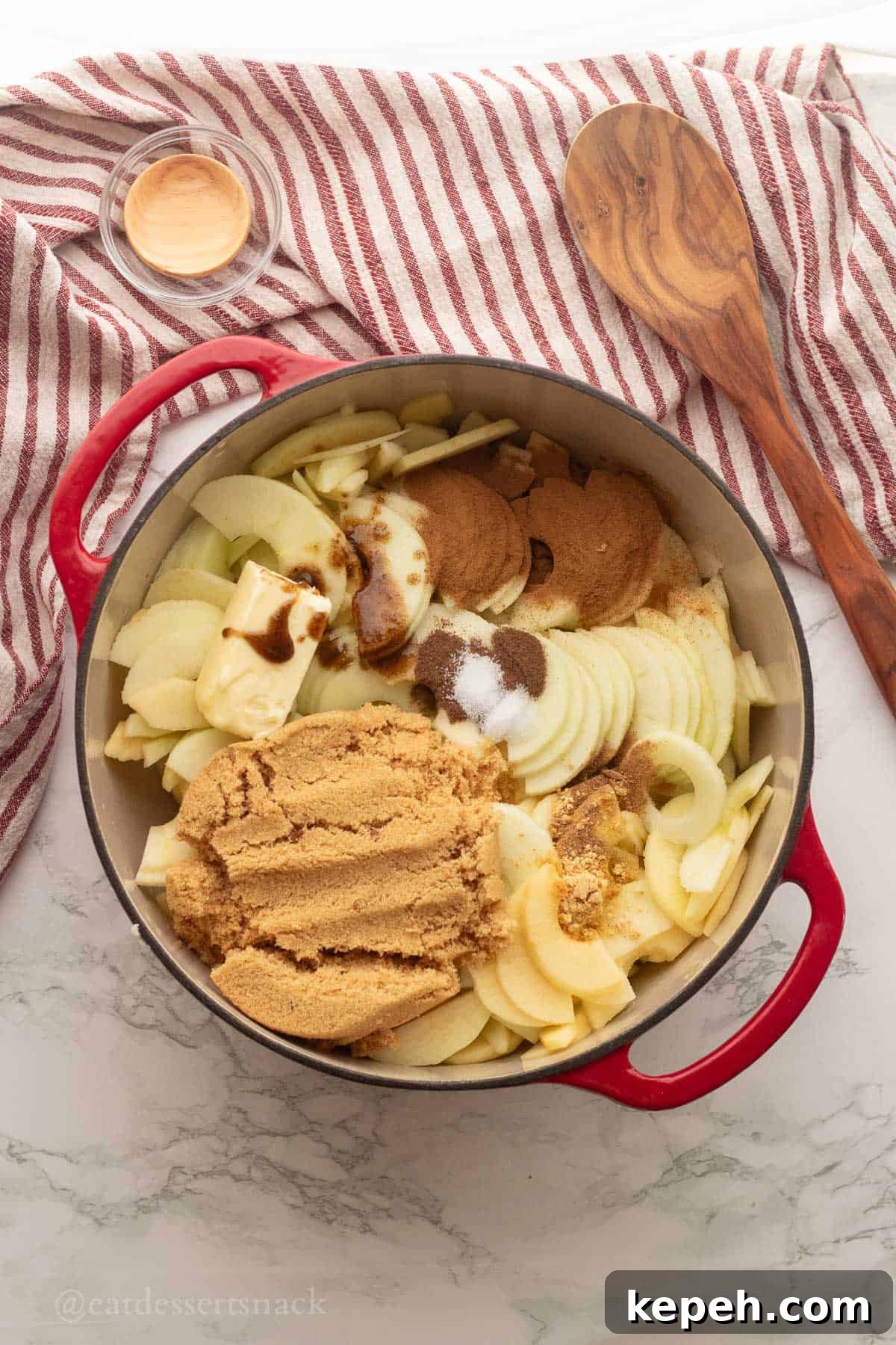 Homemade Apple Pie Filling Recipe for Perfect Rustic Pies 5 Red pan full of raw apple pie filling ingredients.