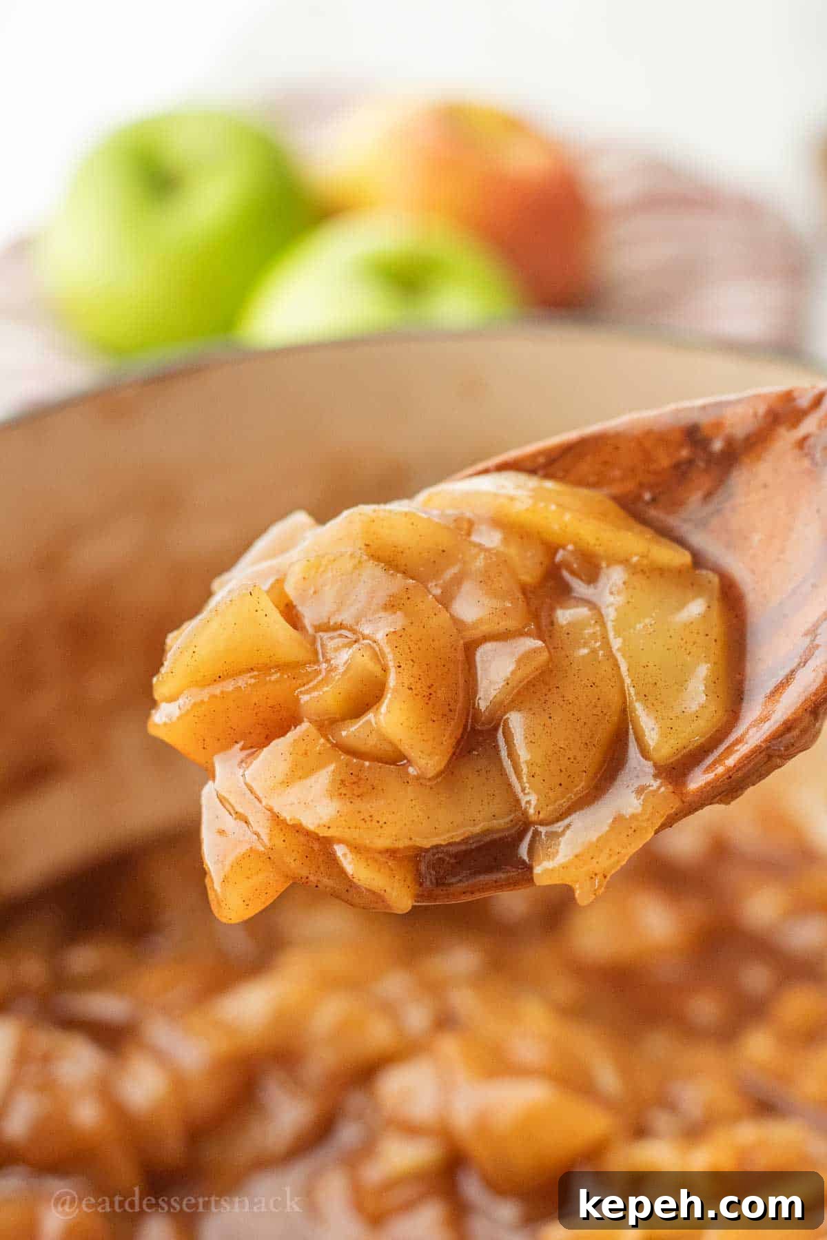 Homemade Apple Pie Filling Recipe for Perfect Rustic Pies 6 Cooked apple pie filling in wooden spoon above pot.