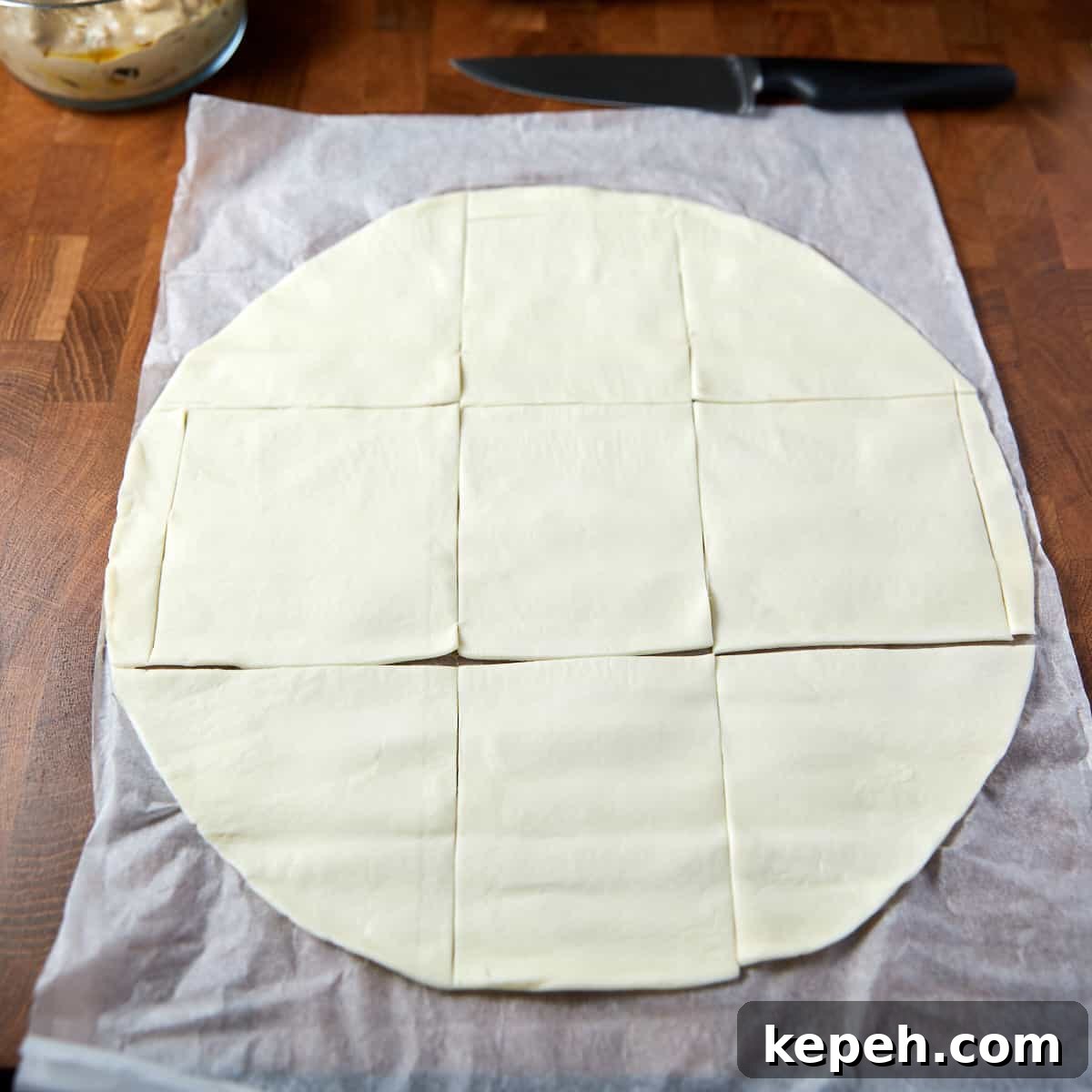 Photo showing the unrolled puff pastry cut into squares.