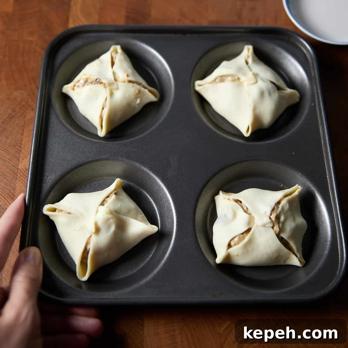 Photo showing the puff pastry corners folded over to the middle over the mushroom filling.