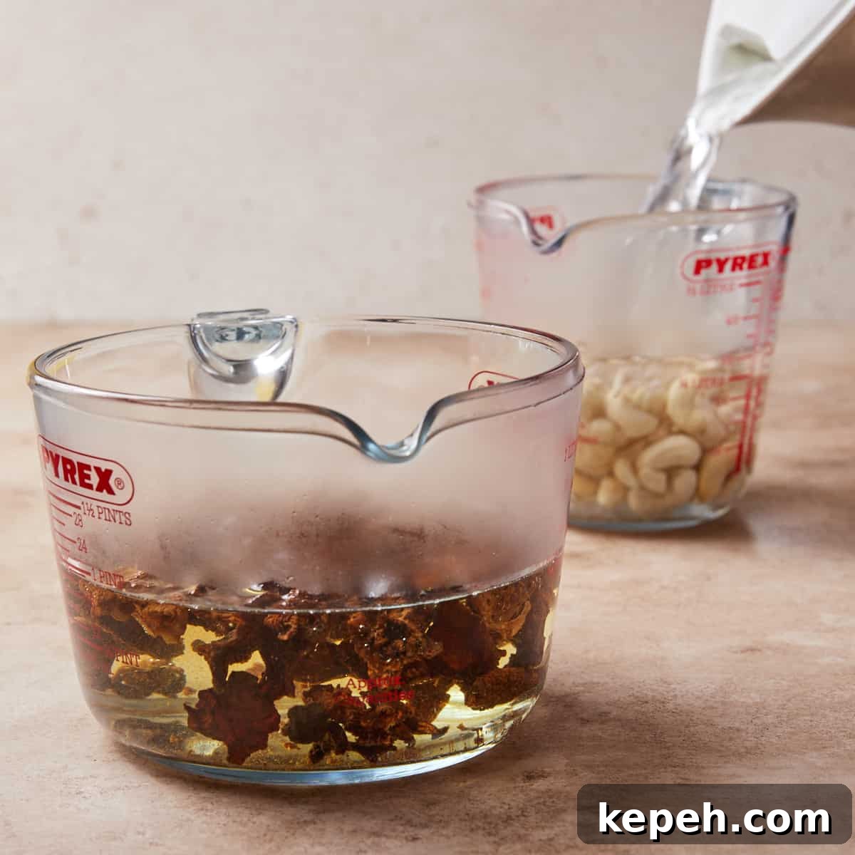 Photo showing cashews soaking in boiling water in a jug.