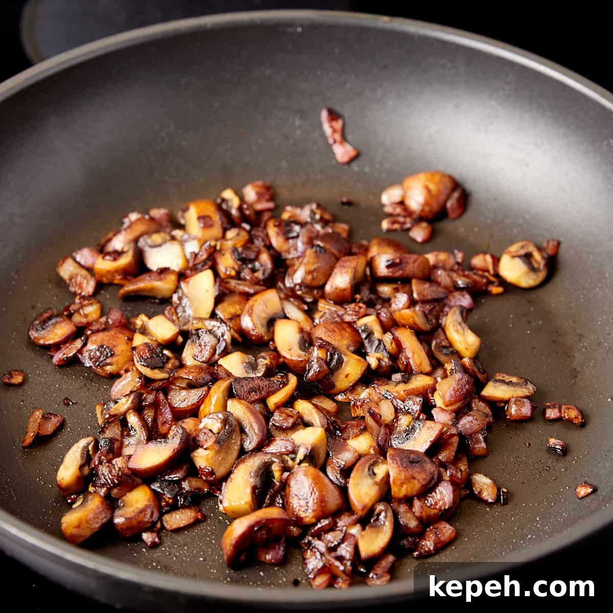 Photo showing browned mushrooms in a frying pan.