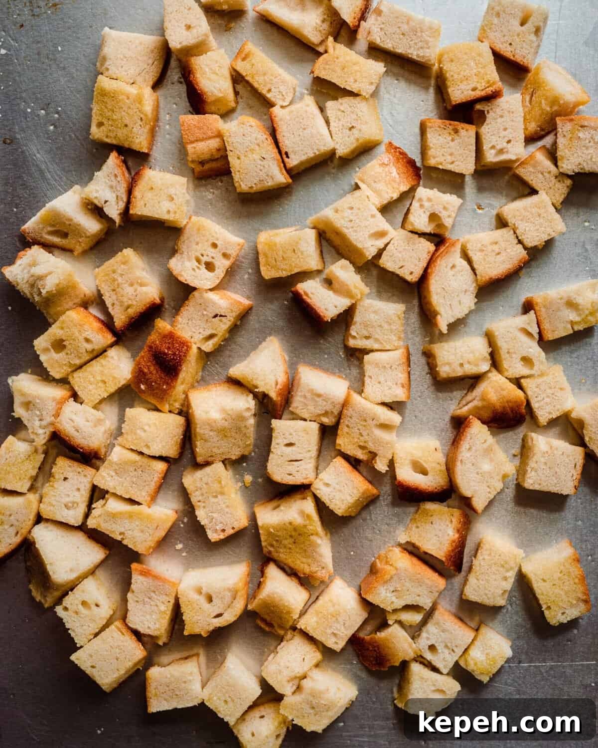bread cubes tossed with olive oil on sheet pan 