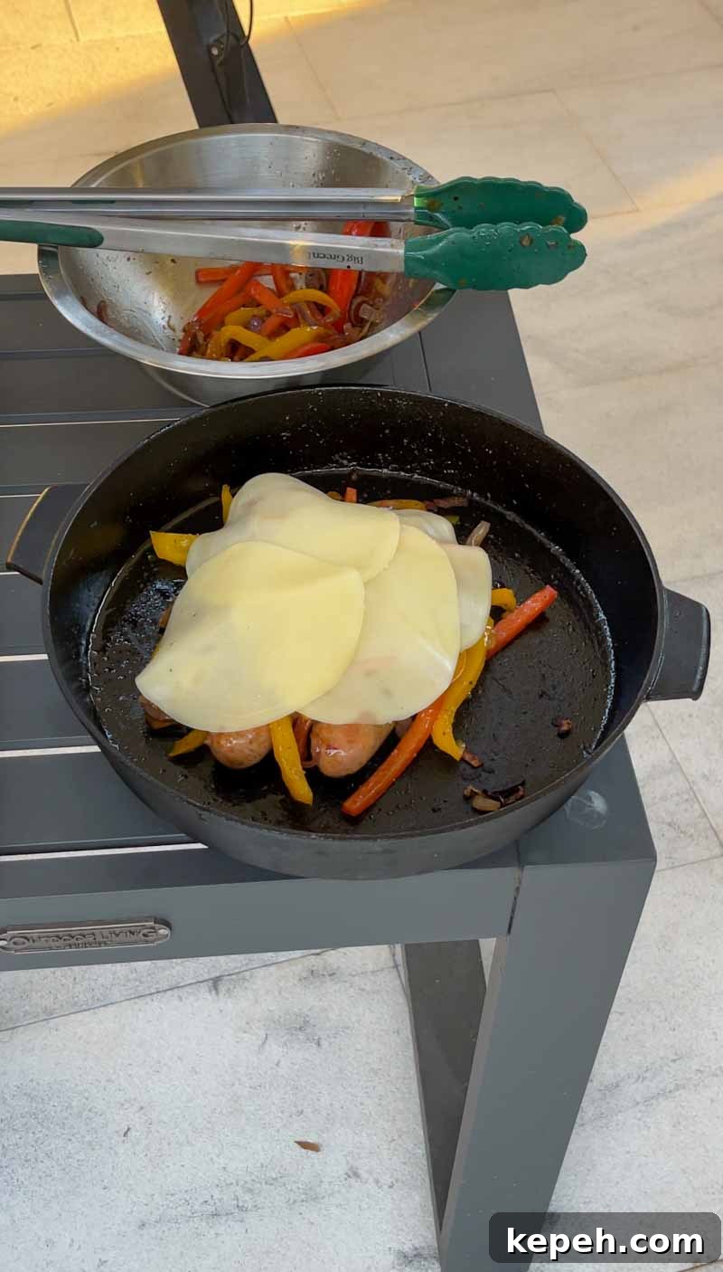 Melting provolone over sausage