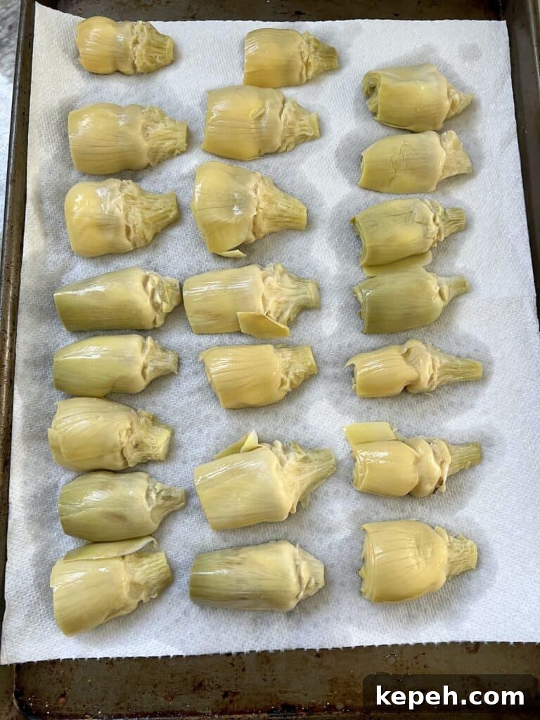 Artichoke hearts draining on paper towels.