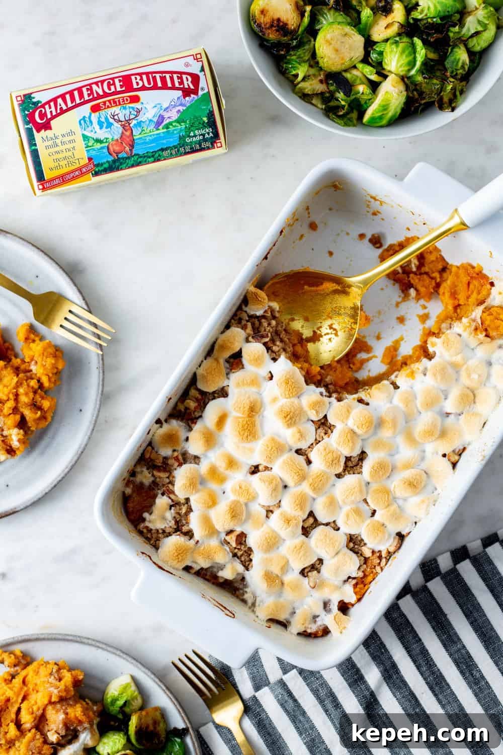 Spoon dishing out sweet potato casserole with streusel topping and sweet potatoes