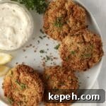 crab cakes on a plate with lemon and parsley