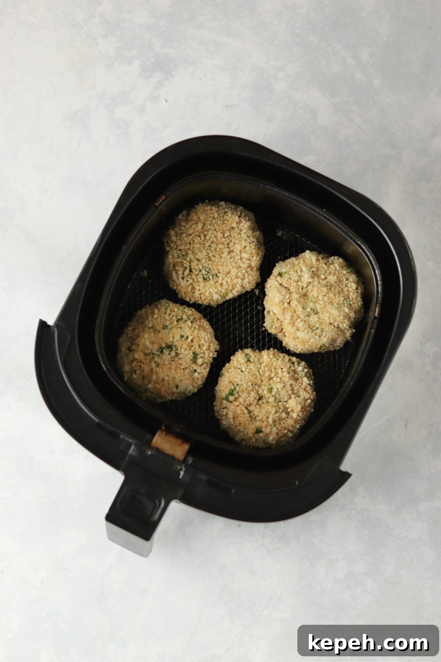 Crispy Air Fryer Crab Cakes Recipe for Golden, Juicy Results 8 uncooked crab cakes in air fryer.