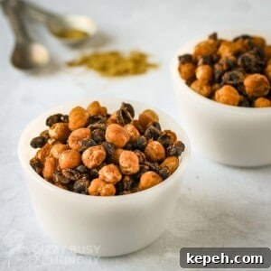 Side shot of two white bowls of chickpeas and black beans with spices and measuring cups in the background.