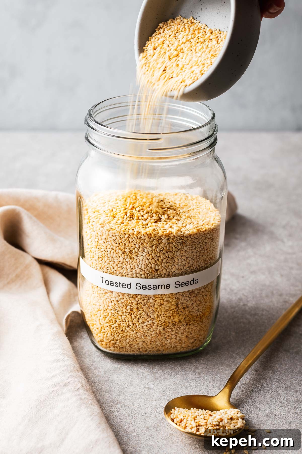 How to Toast Sesame Seeds on the Stove or in the Oven 11 Transferring roasted sesame seeds into an glass jar.