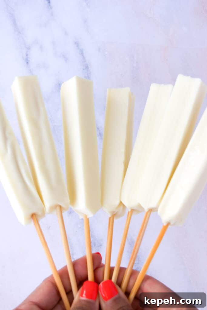 Queijo Coalho Skewers: Complete Guide to Grilling Brazilian Cheese 3 white cheese on skewers held in a hand