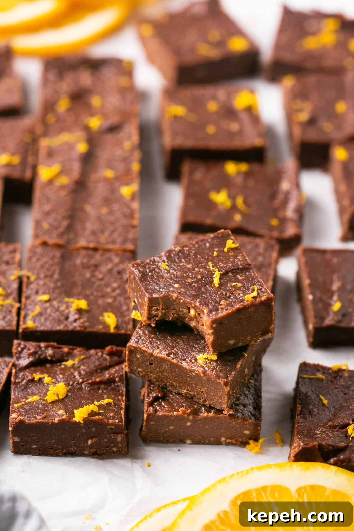 No-Bake Orange Chocolate Fudge Recipe: Zesty Cocoa Treat 2 Pieces of orange chocolate fudge stacked on each other and one of the pieces has a bite out of it.