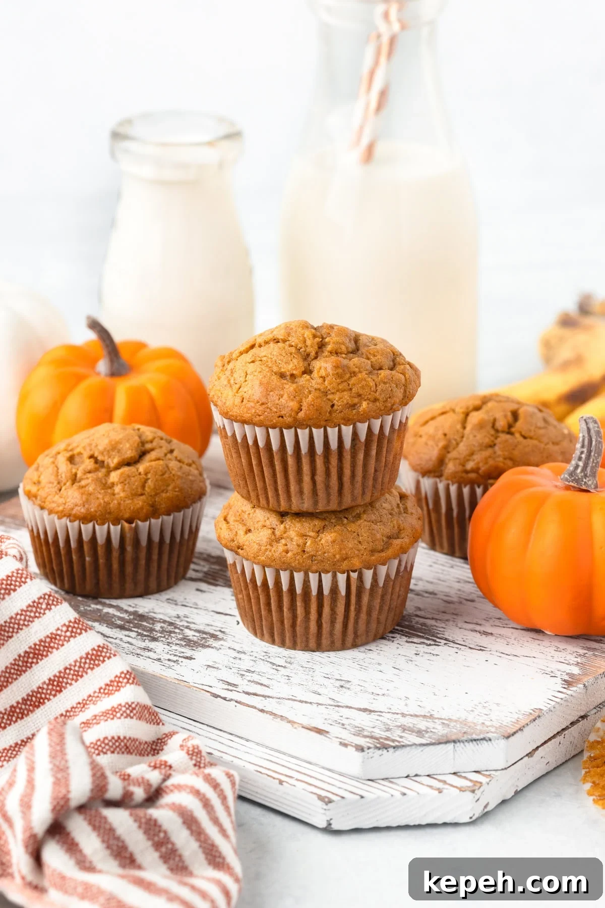 Pumpkin and Banana Muffins stacked on a white board.