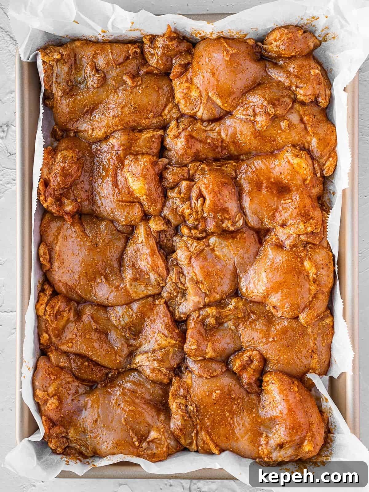 Lebanese Chicken Shawarma Recipe: Wraps or Bowls Made at Home 6 Marinated chicken thighs on a baking sheet.