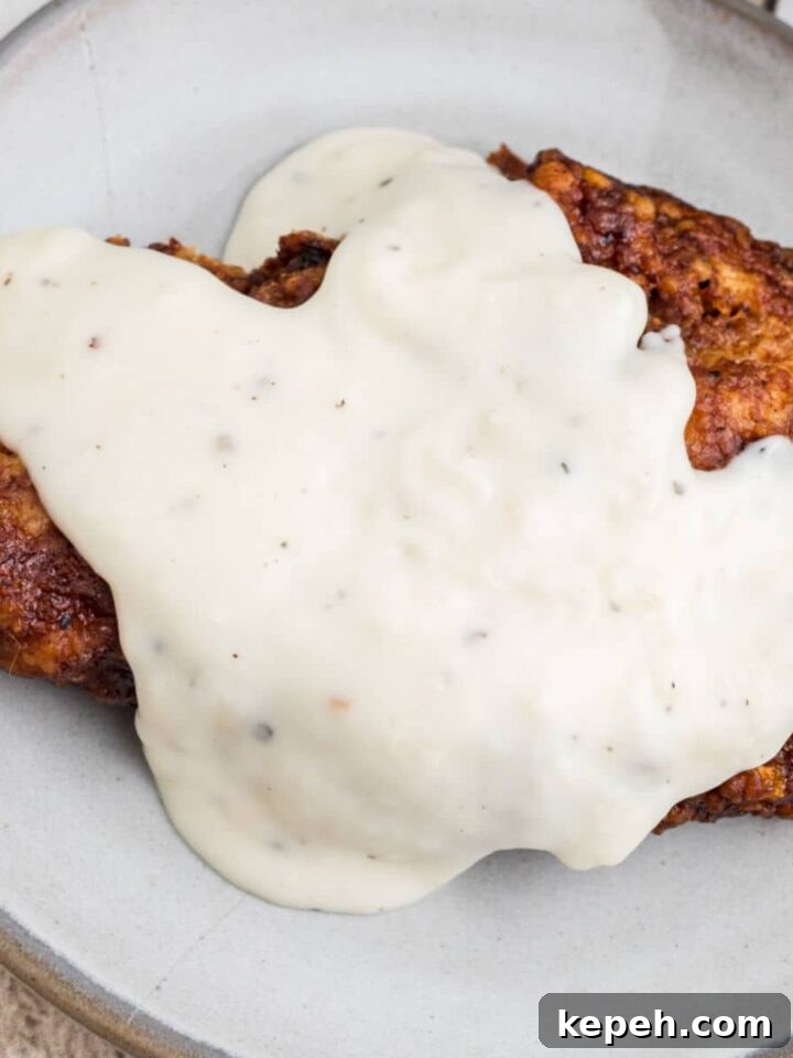 Overhead shot of southern white gravy poured over a pork chop.