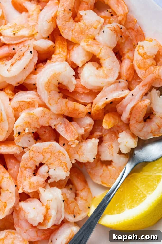Crispy Air Fryer Shrimp from Frozen in 15 Minutes 3 Close-up image of cooked shrimp with a lemon wedge.