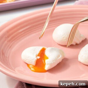 Poached Eggs on a pink plate with a fork.