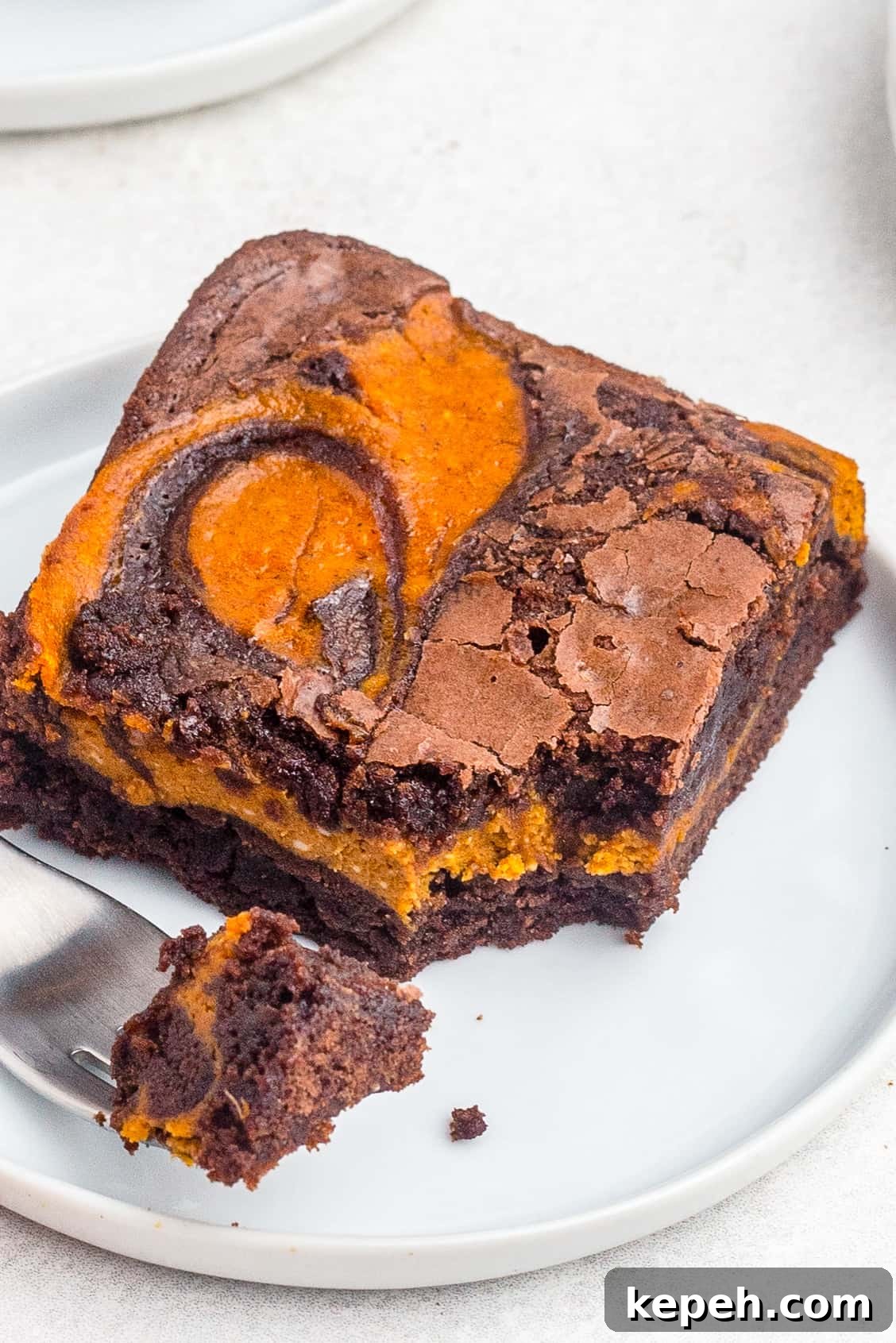 Chewy Pumpkin Brownies with Warm Spice and Chocolate Swirl 3 up close swirled pumpkin brownie on white plate