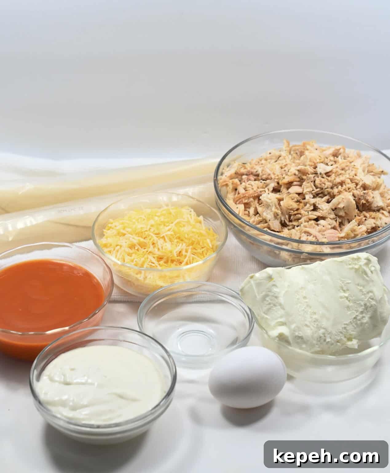 Buffalo Chicken Empanadas Recipe: Crispy Spicy Stuffed Turnovers 4 Shredded meat, cheese, sauce and dough for the dish.