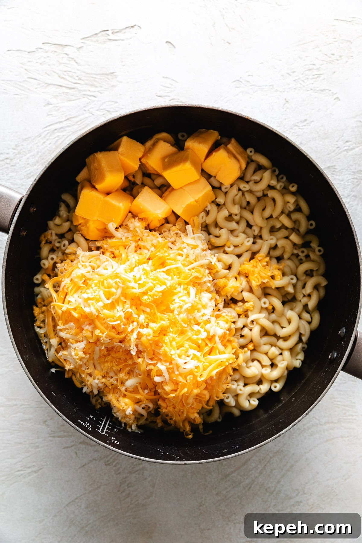 Elbow noodles, cheese, and butter in a pan.