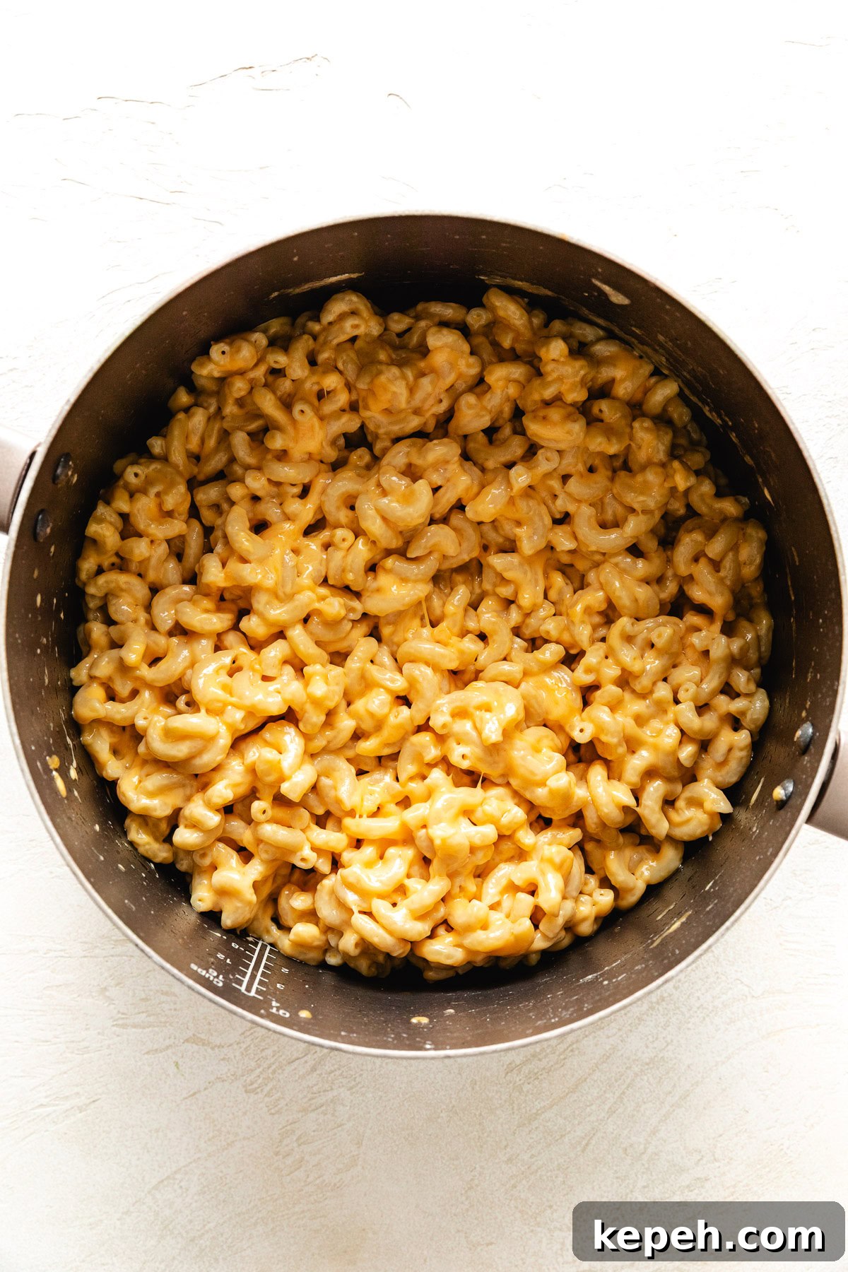 Macaroni noodles stirred with different types of cheese.