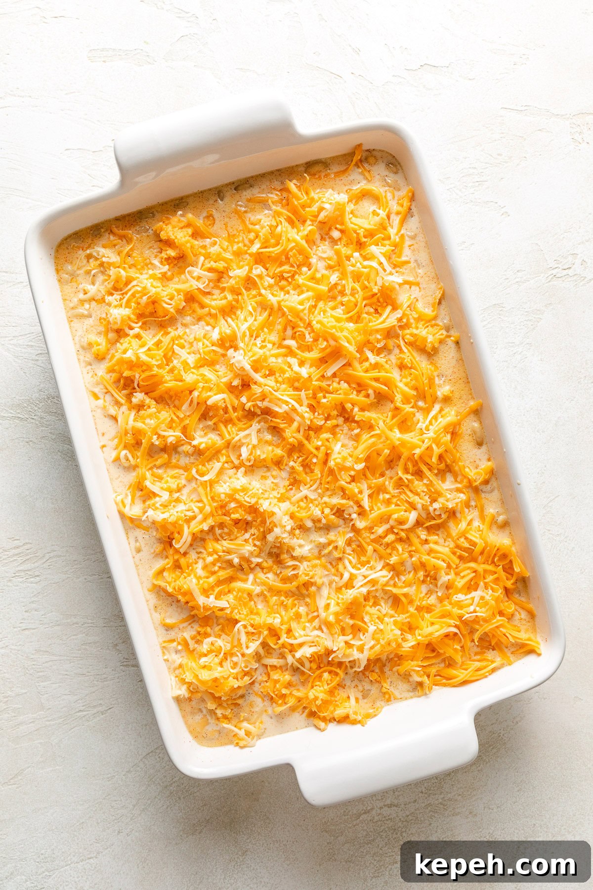 Shredded cheese added to a pan of macaroni.