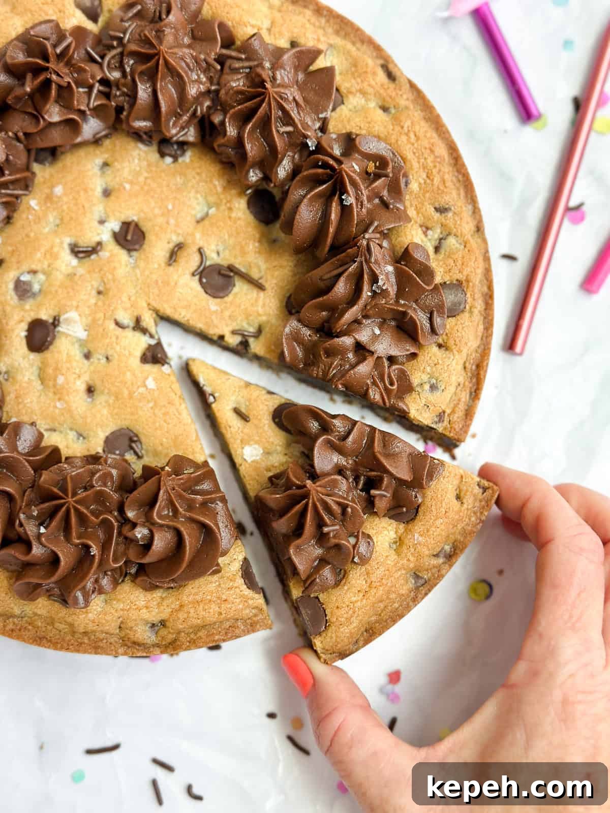 Chocolate Chip Cookie Cake Recipe: Soft, Gooey, Rich 3 a hand reaching in and grabbing as piece of the cookie cake.