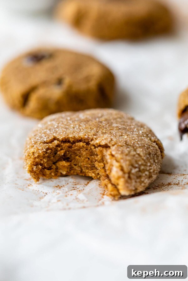 pumpkin cookie on parchment paper with a bite taken out of it